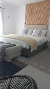 a bedroom with a large bed with pillows at Yellow Door Hermanus in Hermanus
