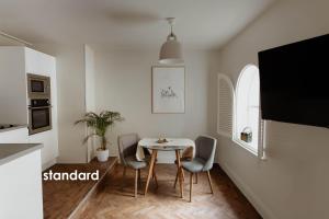 a kitchen and dining room with a table and chairs at HIDEOUT Hotel in Hull