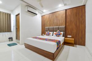 una camera con un grande letto con testiera in legno di FabHotel Maan Palace a Naroda