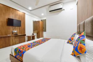 a hotel room with a bed and a tv at FabHotel Maan Palace in Naroda
