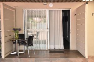 a dining room with a table and a sliding glass door at Arvella Guesthouse in Bloemfontein