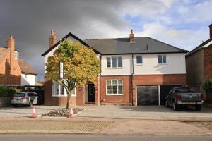 a white and red house with a garage at Magnolia House in Royston