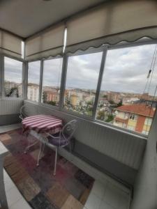 a balcony with a table and chairs and windows at Şirinevler meydan daire in Istanbul