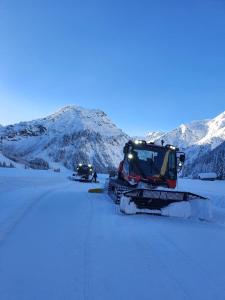 two snow tractors are on a road covered in snow at Ferienwohnung Gasser in Reutte