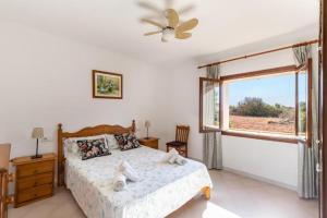 a bedroom with a bed and a window at Villa Sa Llimonera by Slow Villas in Es Llombards