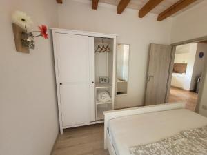 a white bedroom with a closet and a bed at Residence Mama in Rovinjsko Selo