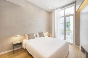 una camera da letto con un grande letto bianco e una finestra di Lisbon Oriente Apartments by Olala Homes a Lisbona