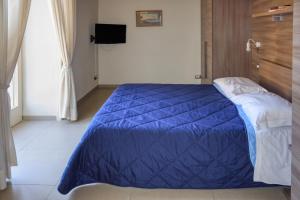 a bedroom with a blue comforter on a bed at Casa Amato in Naples