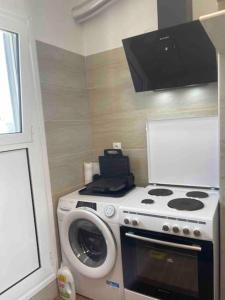 a kitchen with a stove and a washing machine at Rooftop Acropolis Apartment Athens in Athens