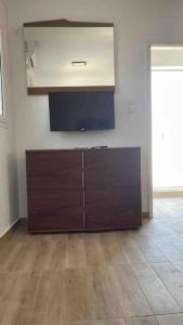 a room with a tv and a wooden cabinet at Rooftop Acropolis Apartment Athens in Athens