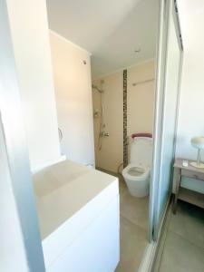 a white bathroom with a toilet and a sink at Panoramic Sea View Apt - 2bed in Limassol