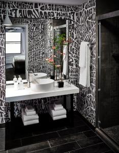 a black and white bathroom with a sink and a mirror at Hotel Zeppelin San Francisco in San Francisco