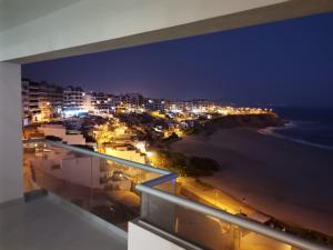 - un balcon offrant une vue sur la plage la nuit dans l'établissement Departamento en Punta Hermosa con Vista al Mar, à Punta Hermosa