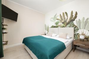 sypialnia z łóżkiem z zielonym kocem w obiekcie Apartamenty Aquamarina by Noclegi Renters w Świnoujściu