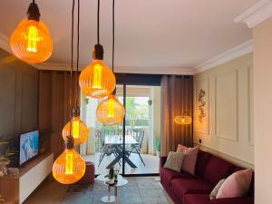 salon z pomarańczowymi lampkami wiszącymi na suficie w obiekcie Casa André - 3 Bedroom Roda Golf apartment nearby entrance and clubhouse w mieście Roda
