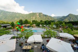 a view of a resort with a pool and mountains at Lago Idro Glamping Boutique in Anfo