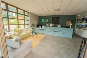 two people standing at a counter in a waiting room at Lago Idro Glamping Boutique in Anfo