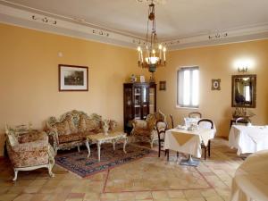 una sala de estar con sofás, mesas y una lámpara de araña. en Palazzo Madeo - Residenza d'Epoca, en Crosia