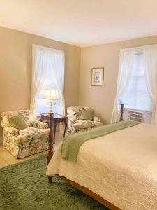 a bedroom with a bed and two chairs and a lamp at Elegant 2BR Apt w 2 Bathrooms in Historic Hamlet by Berkshires & Hudson Valley, Walk to Restaurants in Hillsdale