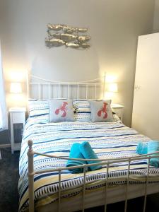 a bedroom with a white bed with blue and white pillows at Richmond Cottage, Minehead 2 mins to beach in Minehead