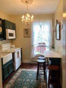 uma cozinha com mesa e cadeiras e um candelabro em Elegant 2BR Apt w 2 Bathrooms in Historic Hamlet by Berkshires & Hudson Valley, Walk to Restaurants em Hillsdale