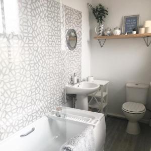 a bathroom with a tub and a sink and a toilet at Richmond Cottage, Minehead 2 mins to beach in Minehead