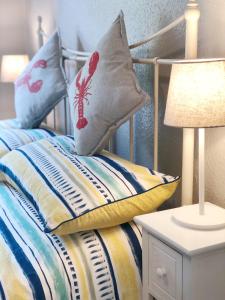 a bedroom with a bed with pillows on it at Richmond Cottage, Minehead 2 mins to beach in Minehead +9 photos