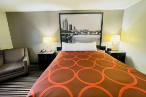 una habitación de hotel con una cama grande y una silla en Super 8 by Wyndham Shakopee, en Shakopee
