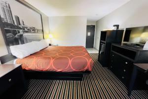 um quarto de hotel com uma cama e uma televisão de ecrã plano em Super 8 by Wyndham Shakopee em Shakopee