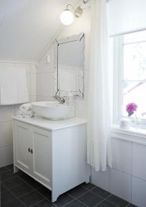 Baño blanco con lavabo y espejo en Jordbærstova Feriehus, en Valldal
