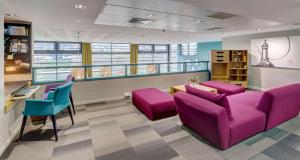 a waiting room with purple furniture in a building at Best Western Plus Hôtel Gergovie in Pérignat-lès-Sarliève