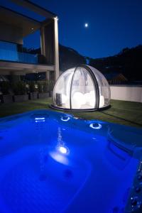 uma casa cúpula com uma piscina azul em frente a uma casa em DOLOMITI EXCLUSIVE YOUR MOUNTAIN SUITE em Pozza di Fassa