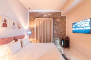 a bedroom with a white bed and a flat screen tv at JEMAA EL FNA Suites & Spa in Marrakesh