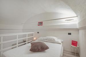 um quarto com uma cama branca e uma almofada em San Bernardo Loft by Wonderful Italy em Gênova