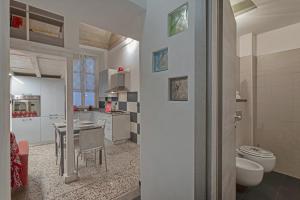 uma casa de banho com WC e uma cozinha com mesa em San Bernardo Loft by Wonderful Italy em Gênova