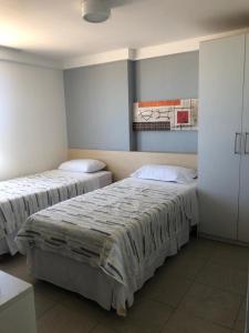 een kamer met 2 bedden en een schilderij aan de muur bij 202 Flat frente Mar - Golden Tower in Natal