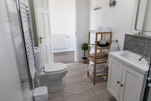 La salle de bains est pourvue de toilettes et d'un lavabo. dans l'établissement doolinyoga luxury accommodation, à Doolin