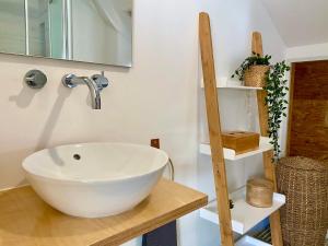 uma casa de banho com um lavatório branco num balcão de madeira em Nestled in Bica: Small Studio, Big Experience em Lisboa