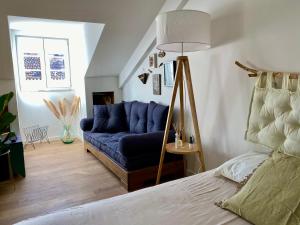 uma sala de estar com um sofá azul e uma cama em Nestled in Bica: Small Studio, Big Experience em Lisboa