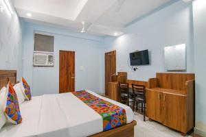 a bedroom with a bed and a kitchen and a television at FabHotel Hari Residency in Chandīgarh