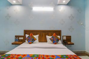 a bedroom with a large bed with colorful pillows at FabHotel Hari Residency in Chandīgarh