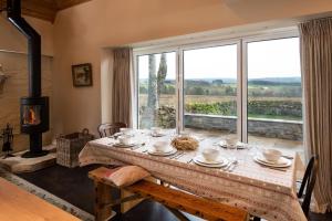 a dining room with a table and a large window at The Bothy at Redheugh in Newcastleton