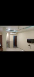 a room with a ceiling fan and a tv on a wall at HoTE 56 indore in Indore