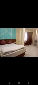 a bedroom with a bed with white sheets at HoTE 56 indore in Indore