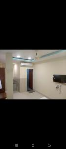 a room with a room with a television and a door at HoTE 56 indore in Indore