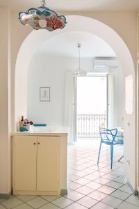 a kitchen with an archway and a table and a chair at Blue Vert Maison - al molo di Gaeta in Gaeta
