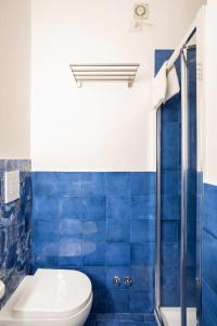 e bagno piastrellato blu con servizi igienici e doccia. di Blue Vert Maison - al molo di Gaeta a Gaeta