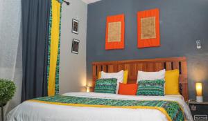 a bedroom with a large bed with colorful pillows at Villa Wilda in Bamako