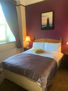a bedroom with a bed with a lighthouse in the background at Buggle's Pub and Accommodation in Kilrush
