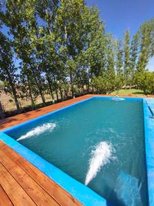 una piscina infinita con terraza de madera y piscina en Casa San Lucas, en San Rafael